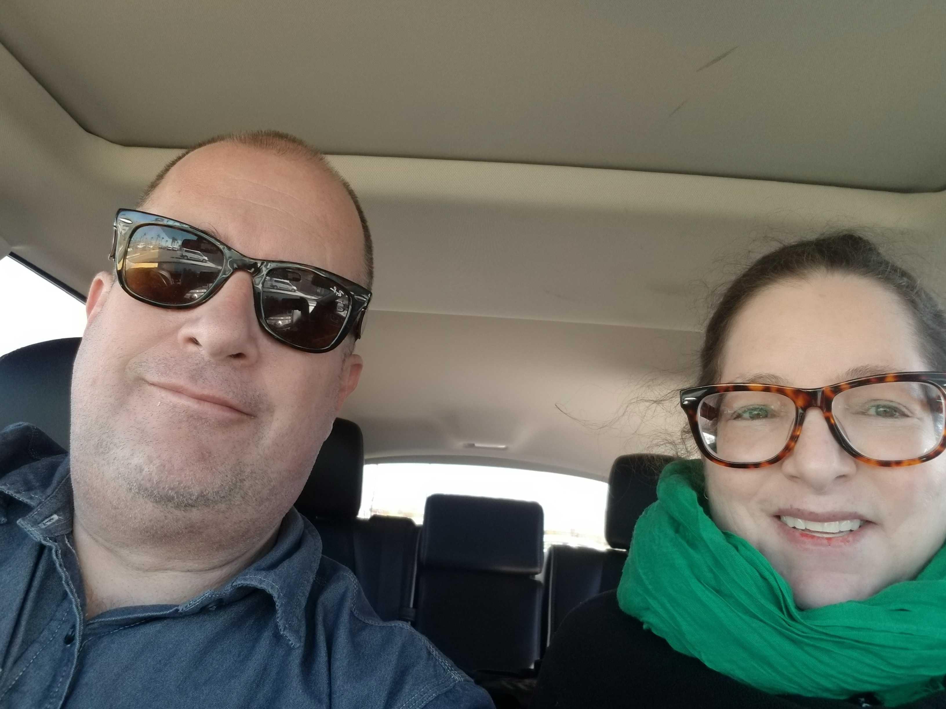 photo of a man and a woman sitting in the front seat of a car